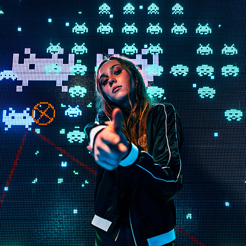 Headerbild des Beitrags: Eine Userin vor einem großen Screen mit "New Tetris"