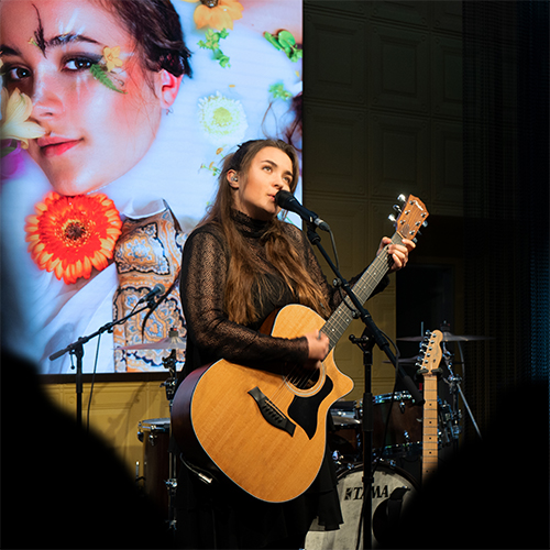 Joya Marleen auf der Bühne im Radio Zürisee Loft mit der Gitarre.